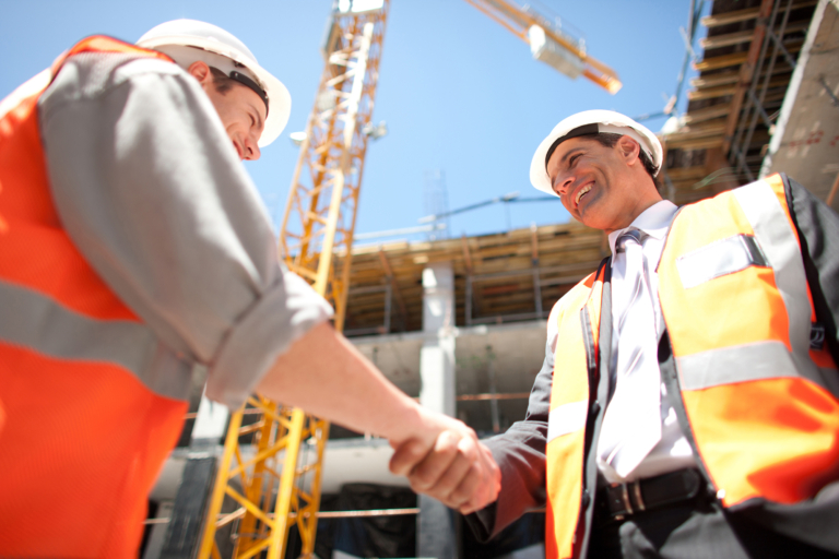 Construction workers shaking hands on construction site