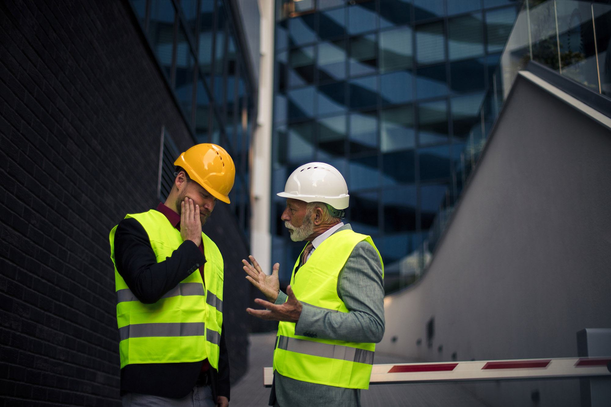 Two Construction workers discussing delays on-site.